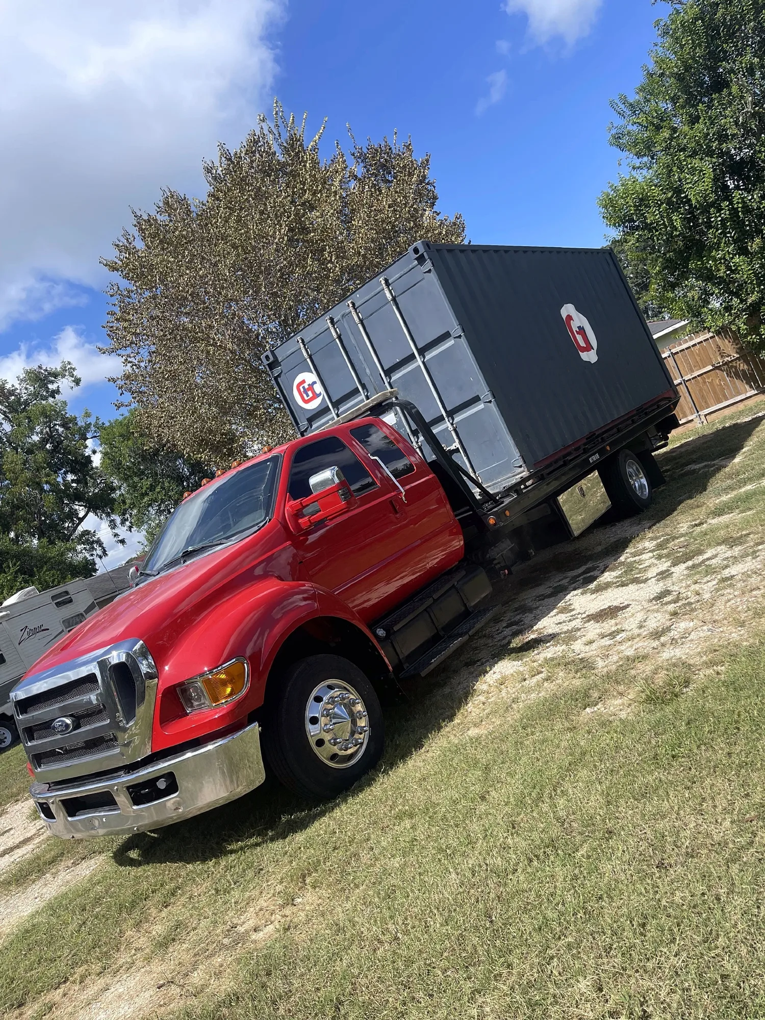 DMC tow truck hauling a gray storage container